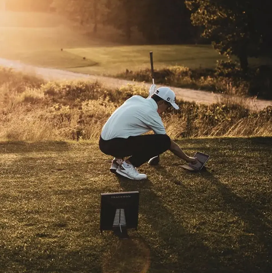 Man checking computer on golf course